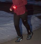 A woman jogging with an LED light clipped on her cuff