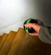 A battery-powered orb light used without the base, aimed by hand to illuminate a flight of stairs