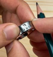 The rotating band on a secret decoder ring is turned to reveal the number associated with a letter