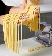 A cook gathers bigoli noodles made using a Marcato pasta machine with the bigoli cutter attachment