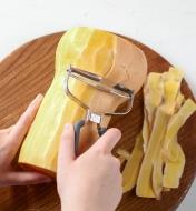 Peeling the thick skin off a butternut squash using the extra-wide Y-peeler