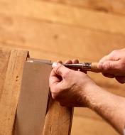 A woodworker uses a 1/8" Narex Richter chisel to trim a tenon