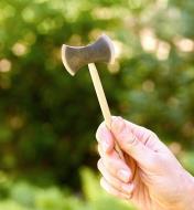 One of the miniature axes in the mini axe-throwing game shown up close in a player’s hand