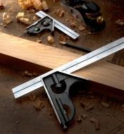 A 12" combination square set on a piece of wooden stock, with a 6" square and a block plane nearby