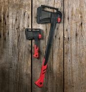 The splitting axe and hatchet held in their plastic storage brackets mounted on the wall of a shed