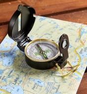 Open engineer's compass placed on a map