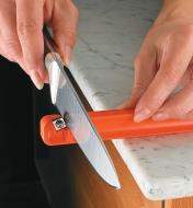 Pulling a knife across the sharpener blade