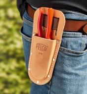 A gardener carries a Felco hand pruner in a pruner holster worn on the hip