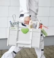 A worker carries a ToolBox SYS3 TB M 237 filled with painting supplies
