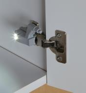 Wireless Hinge LED mounted on a hinge inside a cabinet