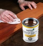 Using a cloth to apply Osmo extra-thin wood wax to a wood surface