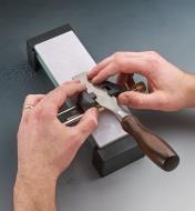 Sharpening a chisel on a glass stone held in a field holder