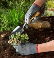 Wearing a pair of lightweight work gloves while planting in the garden
