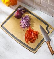 Chopped onions and peppers on a Gourmet cutting board