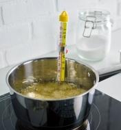The candy and deep-fry thermometer clipped to a pan of boiling syrup