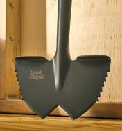 A close view of the root-cutter lawn edger’s blade, showing the bevelled tips and saw teeth