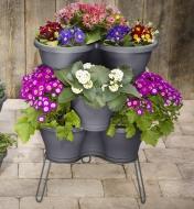 Support soutenant un sous-pot et des pots de jardin dans lesquels poussent des fleurs