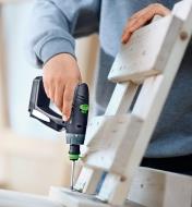 Installing a hinge using a CXS Cordless Drill to secure the screws