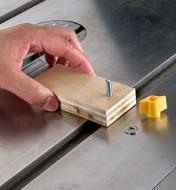 A block of plywood being mounted to a Zeroplay miter stop to create a stop block on a table saw