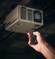 Pointing a remote control at a ceiling-mounted Rikon air cleaner