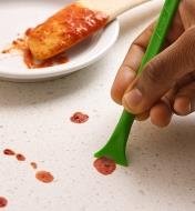 Scraping away sauce splatters using the wide-blade Scrigit scraper
