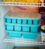 Three covered Souper Cube trays stacked in a freezer