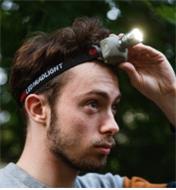 A man wearing the Cree LED headlamp switches the light on