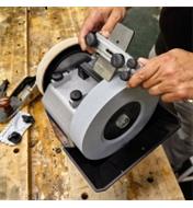 Set in a square-edge jig, a plane blade is sharpened on a Tormek T-8 sharpening machine