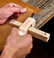 Using the leather strap cutter to cut a band of a consistent width from a larger piece of leather