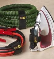 Stretch versions of the storage wraps holding booster cables, a vacuum hose and the cord of an iron