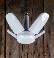 A directional LED ceiling light with its arms half-raised at an angle to cast light over a wide area