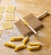 Rolled dough on a wooden rod with the gnocchi and garganelli paddle