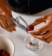 Placing a cherry in the holder of the olive and cherry pitter