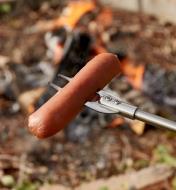 Close-up view of food item held on the tines of the telescoping campfire fork
