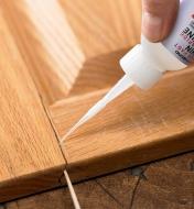Applying Starbond thin CA glue to a crack in a wooden panel