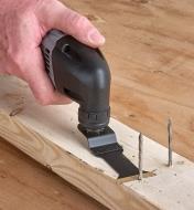 Using an oscillating multi-tool with a TiN-coated blade to flush-cut nails projecting from a 2x4