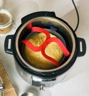 Interlocking handles of the silicone pressure cooker sling shown inside a multi-cooker
