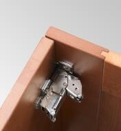A Blum standard 155° zero-protrusion  soft-close clip-top overlay hinge is hidden by closed cabinet door 