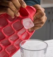 Pushing out a single frozen cube from the extra-large ice cube tray