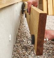 Fastening a ledger and deck-to-wall spacers to a structure using lags