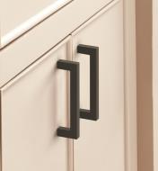 Two matte black Monument handles mounted vertically to two cupboard doors