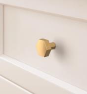 Champagne bronze Caliber knob mounted to a drawer