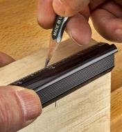 Marking wood with a pencil set against the edge of a Veritas edge rule saddling a workpiece corner