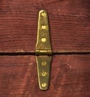 A brass strap hinge fastened with brass screws