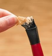 Pulling dried glue from the bristles of the narrow silicone glue brush