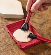 Glue brushes are dipped into adhesive held in the silicone gluing set’s glue tray