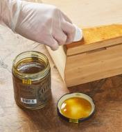Applying Odie’s Dark Oil to a block of wood