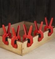 Cinq pinces de serrage pour bord pressant des bandes de chant sur le dessus d'un tiroir en bois