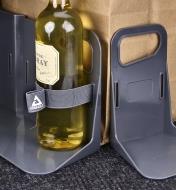 A close view of a bottle of wine secured to a cargo-holder bracket with a 9"" strap