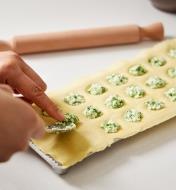 Placing filling in the cupped recesses of the ravioli mold